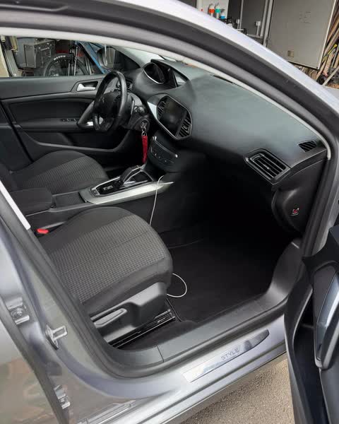 Habitacle d'une Peugeot 308 après nettoyage : sièges, console et moquette avant
